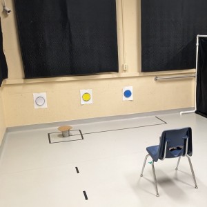 CCHIL testing room with chair, bucket, and white, blue, and yellow dots on the wall