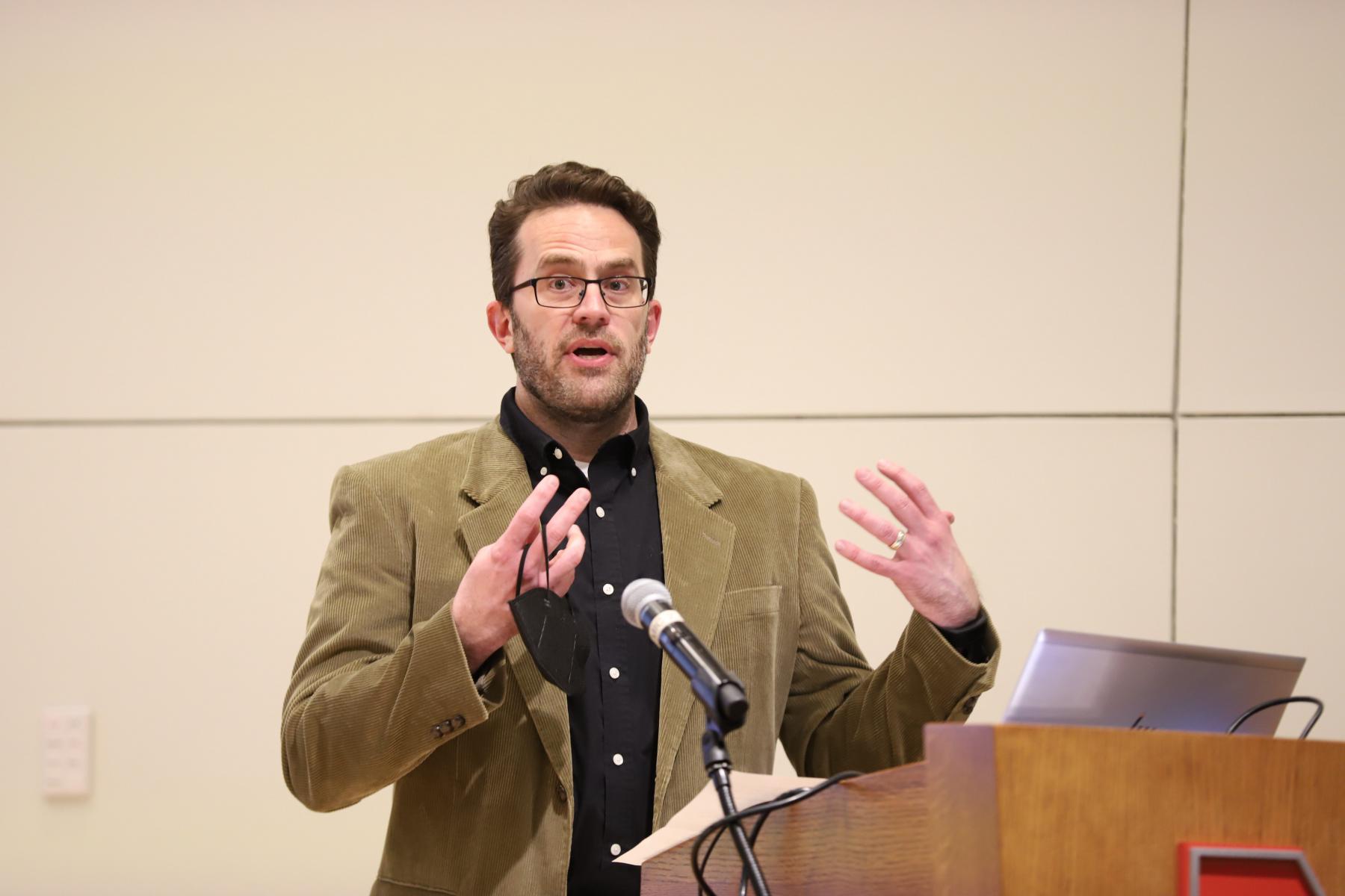 Dr. Jeffrey Stevens at podium introducing speakers