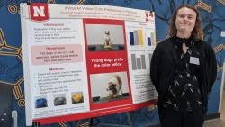 Susannah Couture standing next to research poster on color study.